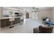 Open-concept living space features a kitchen with bar seating, modern floors, and a sliding barn door at 410 W Seminole Ave, Eustis, FL 32726
