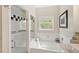 Bright bathroom with enclosed shower and tub, neutral walls, and a window at 476 Water St, Celebration, FL 34747