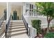 Inviting front porch with a cozy seating area, and a dark green front door with beautiful stairs leading up at 476 Water St, Celebration, FL 34747