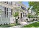 Attractive two-story townhouse with black shutters, lush landscaping, and inviting front porch at 476 Water St, Celebration, FL 34747