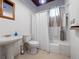 Functional bathroom features a pedestal sink, toilet, tub with shower curtain, and decorative accents at 485 Palm St, Winter Garden, FL 34787