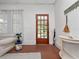 Bright living room featuring a paneled front door, hardwood floors, neutral sofa, and a plant stand at 485 Palm St, Winter Garden, FL 34787