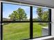 View of the well-maintained back yard from inside, showcasing lush green grass and mature trees on a sunny day at 5384 Barton Dr, Orlando, FL 32807