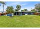 Large backyard featuring mature palm trees, well-maintained lawn, perfect for outdoor living and entertainment at 5384 Barton Dr, Orlando, FL 32807