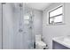 Beautiful bathroom featuring a glass shower with tiled walls, toilet, sink, and a window with natural light at 5384 Barton Dr, Orlando, FL 32807