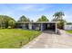 Charming single-story home with well-manicured lawn, covered carport, and inviting front entrance at 5384 Barton Dr, Orlando, FL 32807