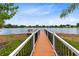 Scenic lake view from a wooden dock, complete with railing; a serene spot for relaxation and enjoying nature at 5384 Barton Dr, Orlando, FL 32807
