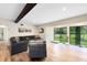 Bright living room featuring modern decor, TV, view of lush backyard through sliding glass doors and wood beam at 5384 Barton Dr, Orlando, FL 32807