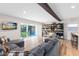 Open-concept living room featuring wood beam, entertainment center and view of backyard through sliding glass doors at 5384 Barton Dr, Orlando, FL 32807