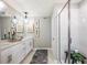 Bathroom featuring double vanity, glass shower with neutral tile, and decorative mirrors at 564 Southern Edge Way, Sanford, FL 32771