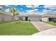 Charming single-story home with a well-manicured lawn, brick driveway, and blue shutters under a beautiful sky at 6013 Mount Zion Cir, Deland, FL 32724
