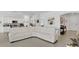 Bright open-concept living space with a white leather couch and modern finishes adjoining the kitchen at 6013 Mount Zion Cir, Deland, FL 32724