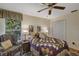 Cozy bedroom with a charming patchwork quilt, ceiling fan, and a comfortable armchair by the window at 612 Golden Dawn, Apopka, FL 32712