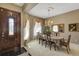 Formal dining room featuring elegant chandelier, decorative mirror, neutral paint, and decorative front door at 612 Golden Dawn, Apopka, FL 32712