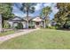 Charming single-story home features a lush lawn, palm trees, and a brick walkway leading to the inviting front entrance at 612 Golden Dawn, Apopka, FL 32712