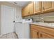 Bright laundry room features a front load washer dryer with wooden cabinets and utility sink at 612 Golden Dawn, Apopka, FL 32712