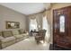 Inviting living room showcasing a comfortable sofa, ornate chair, table, and decorative front door at 612 Golden Dawn, Apopka, FL 32712