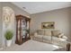 A cozy living room is enhanced by display case, plush sofa, neutral walls, and decorative accents at 612 Golden Dawn, Apopka, FL 32712