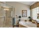 Bright main bathroom featuring a walk-in glass shower, soaking tub and neutral fixtures at 612 Golden Dawn, Apopka, FL 32712
