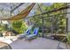 Relax on the patio featuring lounge chairs and a sunshade surrounded by the screened enclosure and lush landscaping at 612 Golden Dawn, Apopka, FL 32712