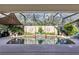 A beautiful in-ground pool is surrounded by lush plants and decorative accents inside a screened enclosure at 612 Golden Dawn, Apopka, FL 32712