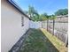 A partial view of the side yard with white gate and a weathered fence at 6554 Meritmoor Cir, Orlando, FL 32818
