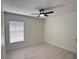 A minimalist bedroom with white tile flooring and ceiling fan at 6554 Meritmoor Cir, Orlando, FL 32818