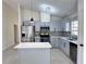 Modern kitchen features stainless steel appliances, gray cabinets, an island, and tile backsplash at 6554 Meritmoor Cir, Orlando, FL 32818