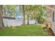 Lush backyard featuring a pristine lawn, white fence, and shaded by mature trees adorned with Spanish moss at 708 S Laurel Ave, Sanford, FL 32771