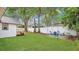 Spacious backyard with green grass, white fence, and a small deck on a white house at 708 S Laurel Ave, Sanford, FL 32771