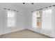 Minimalist bedroom with natural light, neutral carpet, white walls, and sheer curtains at 708 S Laurel Ave, Sanford, FL 32771