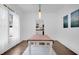 Bright dining room featuring hardwood floors, a view of the kitchen, and a modern light fixture at 708 S Laurel Ave, Sanford, FL 32771