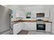 Modern kitchen with white cabinets, stainless steel appliances, stylish wood counters, and marble floors at 708 S Laurel Ave, Sanford, FL 32771