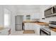 Modern kitchen featuring white cabinets, stainless steel appliances, stylish wood counters, and marble floors at 708 S Laurel Ave, Sanford, FL 32771