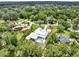 Expansive aerial shot highlighting the home's architectural design and its integration into the lush green surroundings at 7615 Se 12Th Cir, Ocala, FL 34480