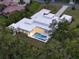 Aerial view of a modern home, showcasing a sleek pool, expansive patio, and lush surroundings at 7615 Se 12Th Cir, Ocala, FL 34480