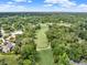 Expansive aerial view of the golf course community surrounded by lush green trees with a blue sky at 7615 Se 12Th Cir, Ocala, FL 34480
