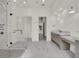Modern bathroom with glass enclosed shower, double vanity, and light grey marble flooring at 7615 Se 12Th Cir, Ocala, FL 34480