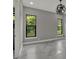 Bright bedroom with marble tile flooring, ample natural light from dual windows, and a stylish light fixture at 7615 Se 12Th Cir, Ocala, FL 34480