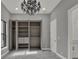 Spacious bedroom with a closet with open doors, chandelier and marble-look floors at 7615 Se 12Th Cir, Ocala, FL 34480