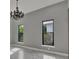 Bedroom with decorative chandelier, two windows overlooking the lush green landscape at 7615 Se 12Th Cir, Ocala, FL 34480