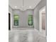 Bright bedroom with two windows, chandelier, and marble-look tile floors at 7615 Se 12Th Cir, Ocala, FL 34480