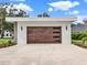 Single-car garage featuring a contemporary design and a wood-look garage door at 7615 Se 12Th Cir, Ocala, FL 34480