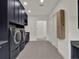 Modern laundry room featuring front load washer and dryer, gray cabinetry, and ample storage space at 7615 Se 12Th Cir, Ocala, FL 34480