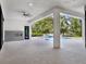 Open patio area with ceiling fan and fireplace overlooking the pool and wooded backyard at 7615 Se 12Th Cir, Ocala, FL 34480