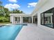 Bright backyard featuring a sparkling pool, outdoor kitchen, and covered patio area at 7615 Se 12Th Cir, Ocala, FL 34480
