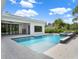 Backyard pool and patio view, showing outdoor fireplace and modern home design at 7615 Se 12Th Cir, Ocala, FL 34480