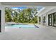 View of pool with waterfall feature and the outdoor kitchen with stainless steel grill at 7615 Se 12Th Cir, Ocala, FL 34480