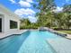 Backyard pool with spa and waterfall features, surrounded by lush green landscaping at 7615 Se 12Th Cir, Ocala, FL 34480