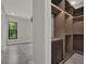 Spacious walk-in closet with custom shelving, drawers, and ample storage; adjoins to bedroom with window view at 7615 Se 12Th Cir, Ocala, FL 34480